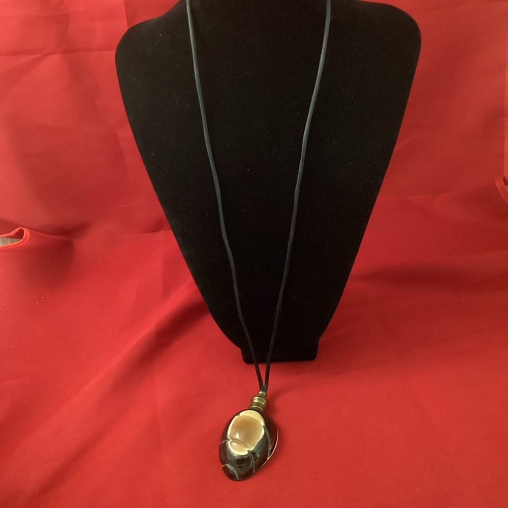 Signed horn pendant on a lace necklace